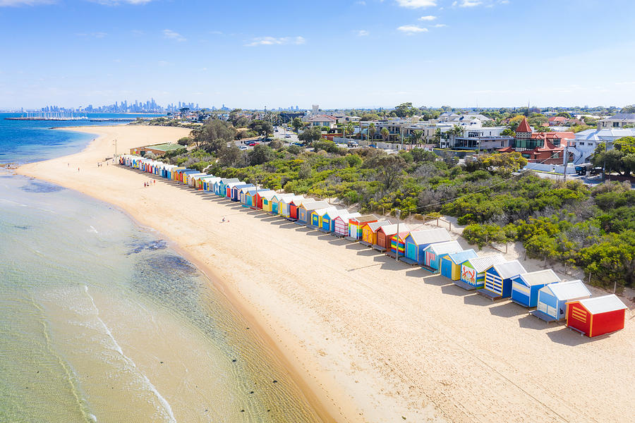 Aerial view of colorful Brighton Bathing Boxes on white sandy beach at Brighton beach with city in background in Melbourne, Victoria, Australia. Photograph by Prasit photo