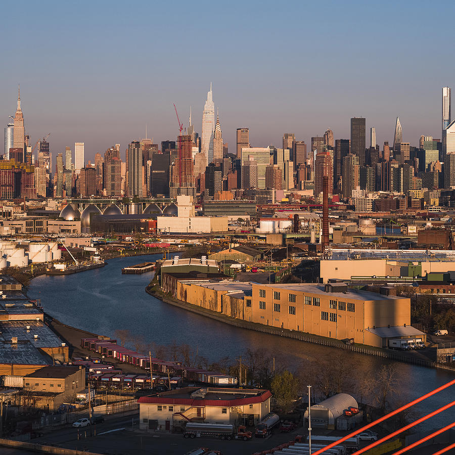 Aerial view of Midtown Manhattan over the industrial district in Williamsburg, Brooklyn, New York, illuminated by sunlight in the early morning. Stitched high-resolution vertical panorama. Photograph by Alex Potemkin