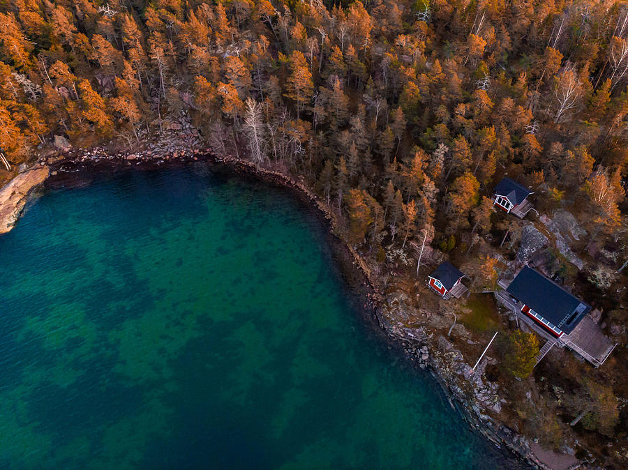 Aerial view of red houses with the sea and nature in the Stockholm archipelago. Photograph by Artur Debat