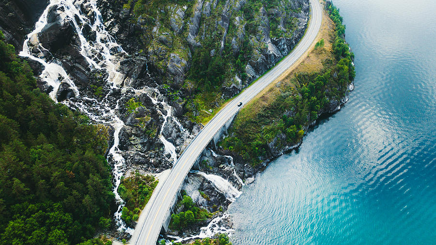 Aerial view of scenic mountain road with car, sea and waterfall in Norway Photograph by Anastasiia Shavshyna