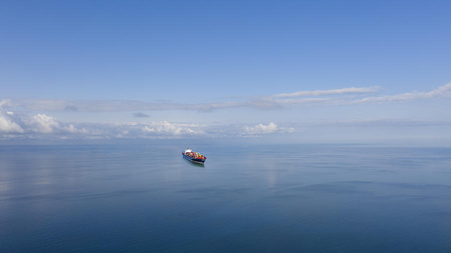 Aerial view of single big cargo ship on sea over sunny blue sky Photograph by Bfk92