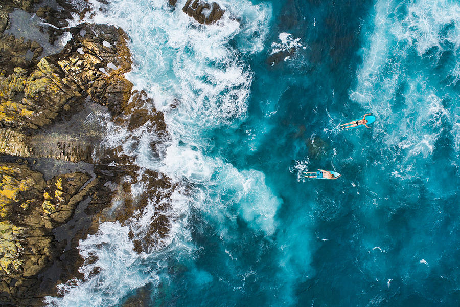 Aerial view of surfers on their surfboards. Photograph by Nazar_ab