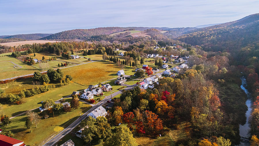 Aerial view of the small town surrounded by the forest in the mountain in autumn morning. Photograph by Alex Potemkin