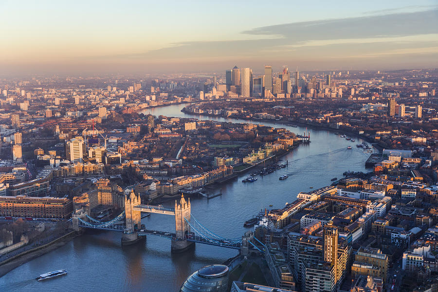 Aerial view of Tower Bridge and Canary Wharf skyline at sunset Photograph by DieterMeyrl