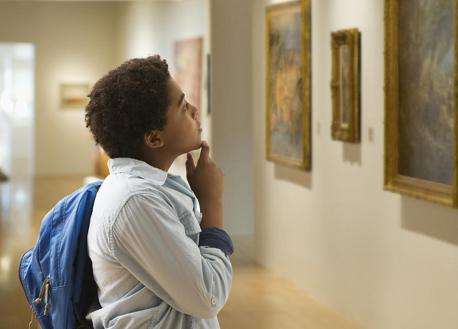 African American boy looking at painting in museum Photograph by Jose Luis Pelaez Inc