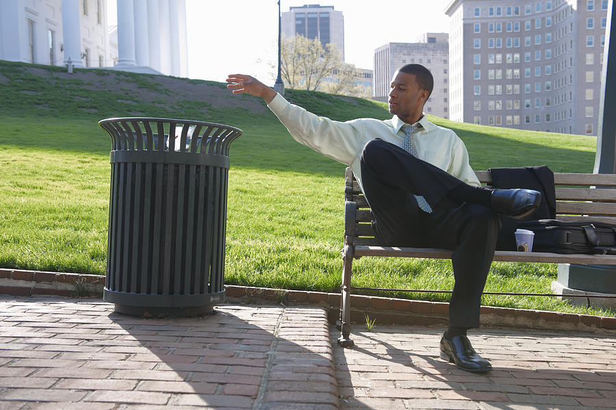 African American businessman throwing trash in garbage can Photograph by Jacobs Stock Photography Ltd