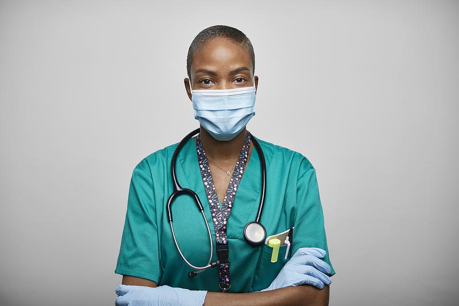 African American Doctor/Nurse With Arms Crossed Against White Background Photograph by Morsa Images