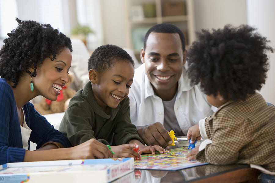 African American family playing board game together Photograph by Jose Luis Pelaez Inc