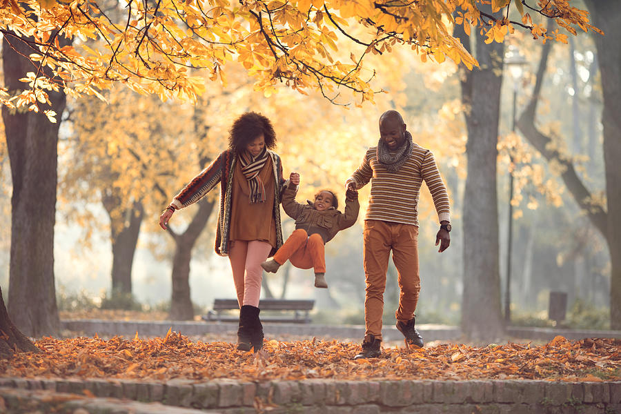 African American family walking and having fun in autumn park. Photograph by Skynesher