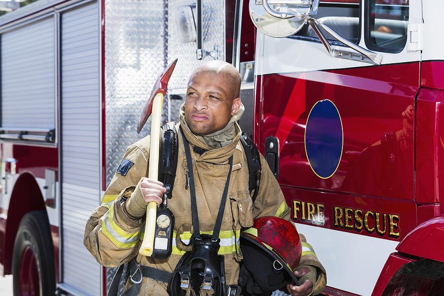 African American fire fighter carrying axe Photograph by Kali9