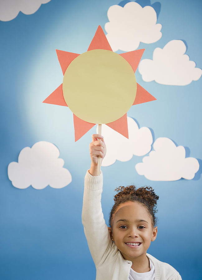 African American girl holding up paper sun Photograph by JGI/Jamie Grill