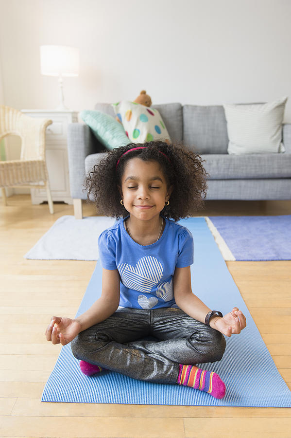 African American girl meditating on yoga mat Photograph by JGI/Jamie Grill