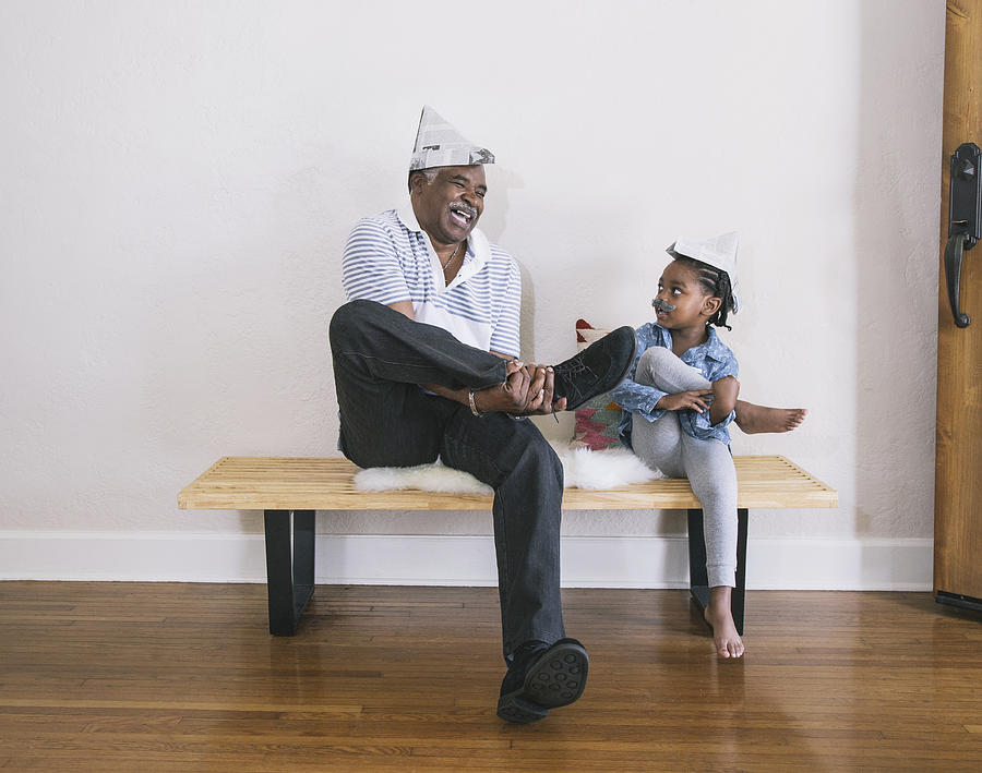 African American grandfather and granddaughter playing on bench Photograph by Hello Lovely