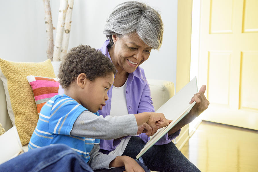 African American grandmother showing book to grandson, smiling Photograph by Johnny Greig