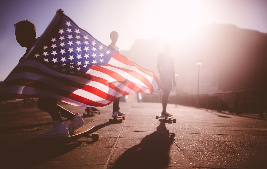 African American longboarder flying an American flag Photograph by Wundervisuals