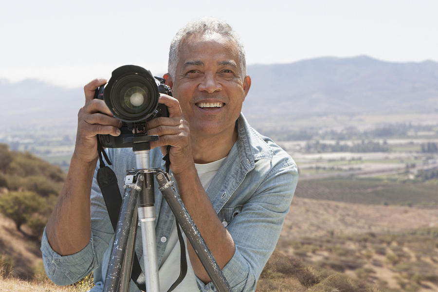 African American man photographing in scenic remote landscape Photograph by Jose Luis Pelaez Inc