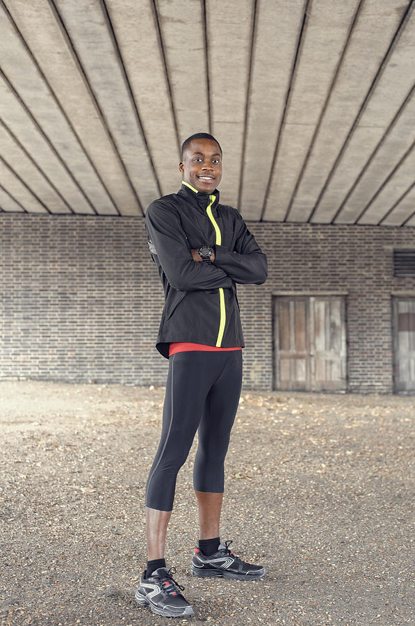 African American runner standing under concrete structure Photograph by Jacobs Stock Photography Ltd