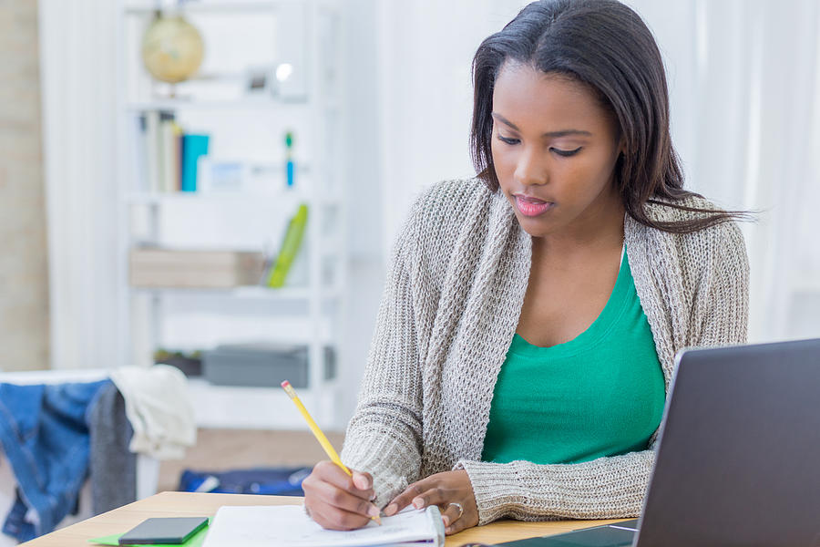 African American teenager concentrates while working on homework assignment Photograph by SDI Productions