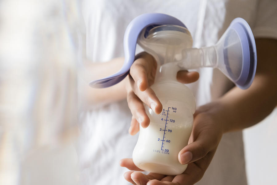 African American woman holding milk in breast pump Photograph by JGI/Jamie Grill