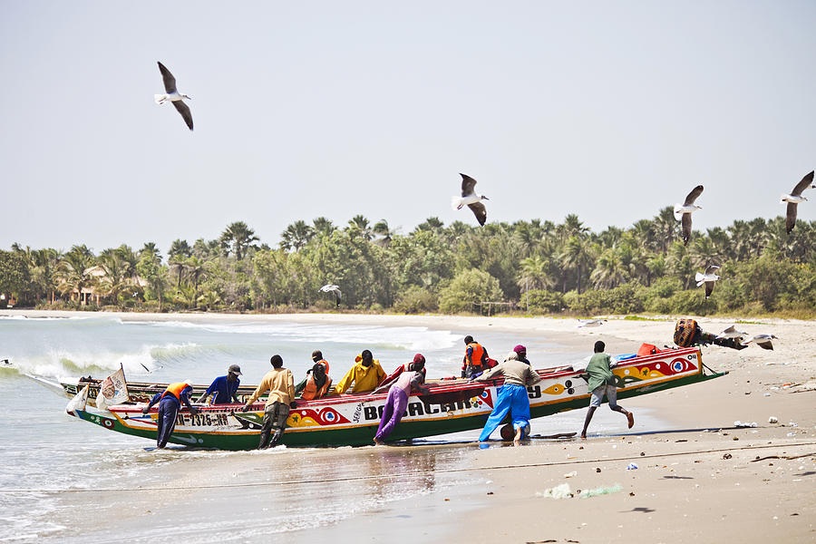 African beach scene with fishing boat. Photograph by Peeterv