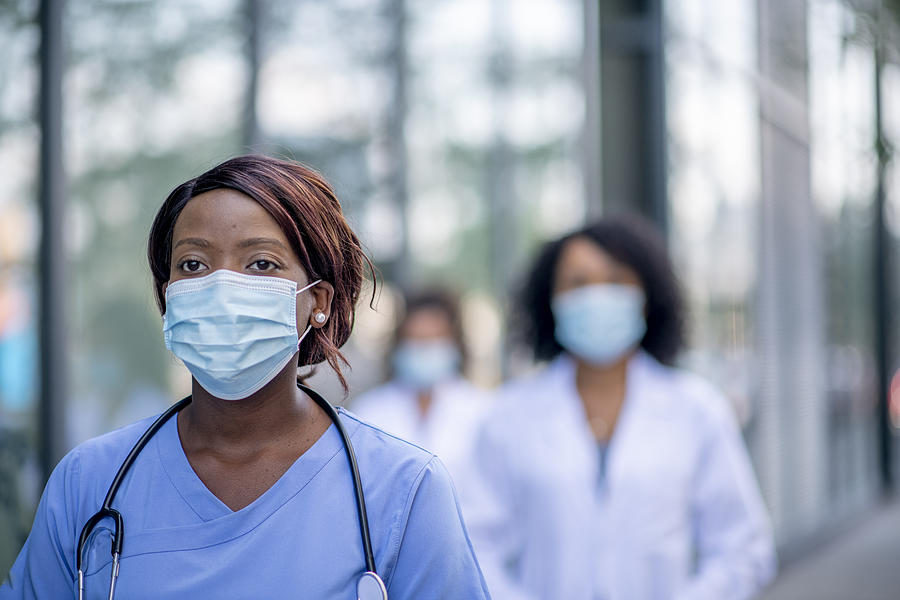African female nurse wearing a face mask Photograph by FatCamera