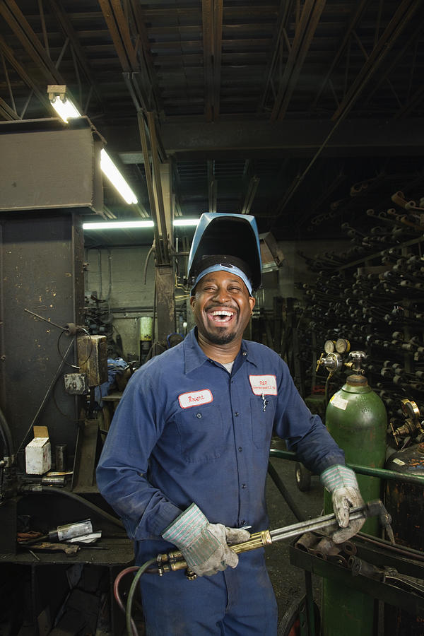 African welder working in repair shop Photograph by Jon Feingersh Photography Inc