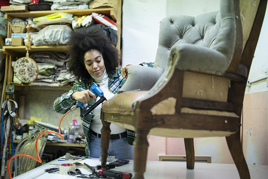 African woman renovating a chair in upholstery workshop Photograph by Vladimir Vladimirov