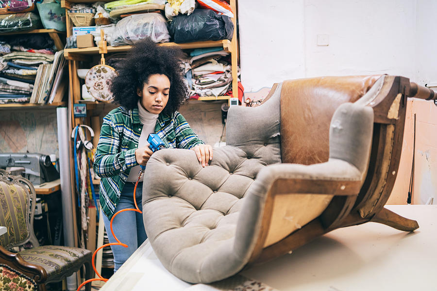 Afro Female Refurbishing Chair In Upholstery Workshop Photograph by Valentinrussanov