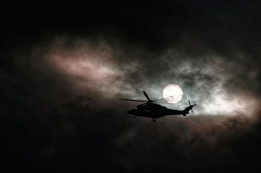 Airborne Helicopter in storm cloud sunset silhouette. Photograph by Geoff Childs