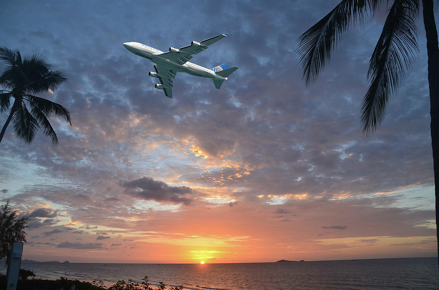 Aircraft flying in tropical dawn sky. Thailand. Photograph by Geoff Childs