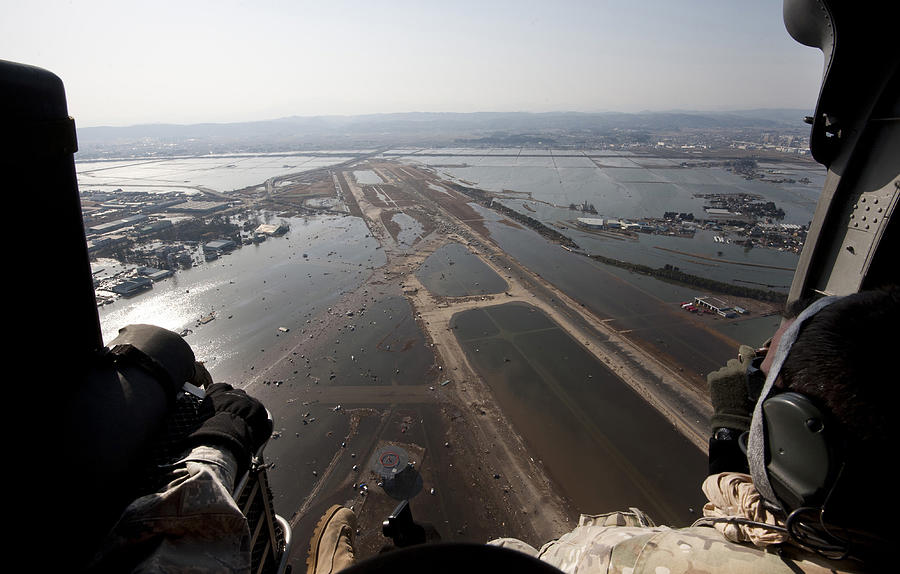 Airmen fly over the Sendai Airport in Japan to survey the tsunami aftermath. Photograph by Stocktrek Images