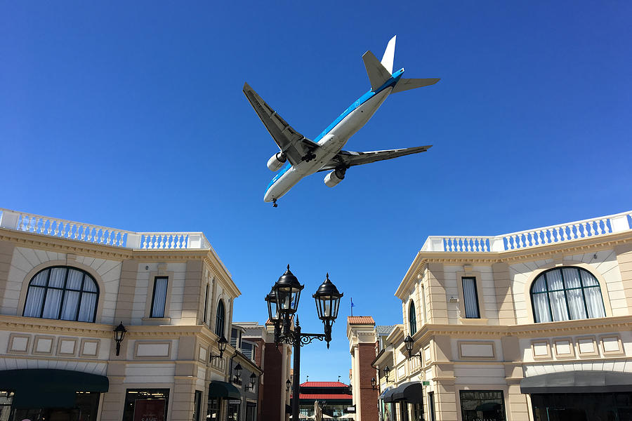 Airplane Flying over McArthurGlen Designer Outlets Photograph by Yun Han Xu