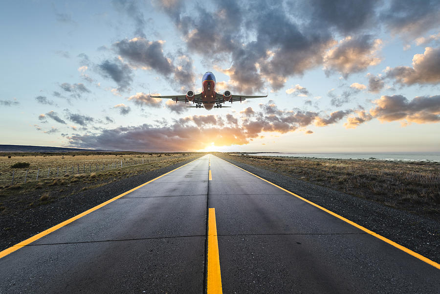 Airplane landing on a road at sunset Photograph by © Marco Bottigelli
