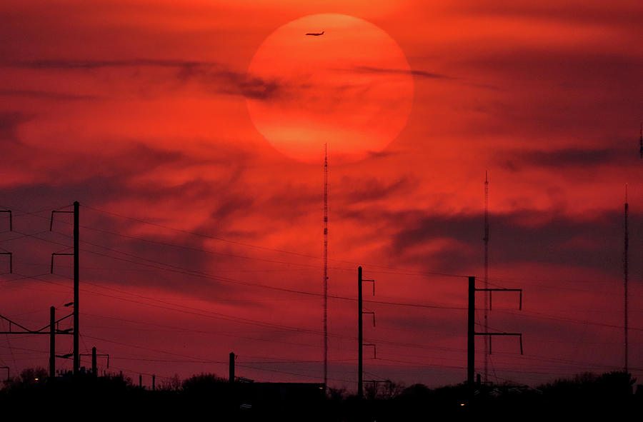 Airplane Passing in Front of Setting Sun Over Philadelphia Photograph by Linda Stern