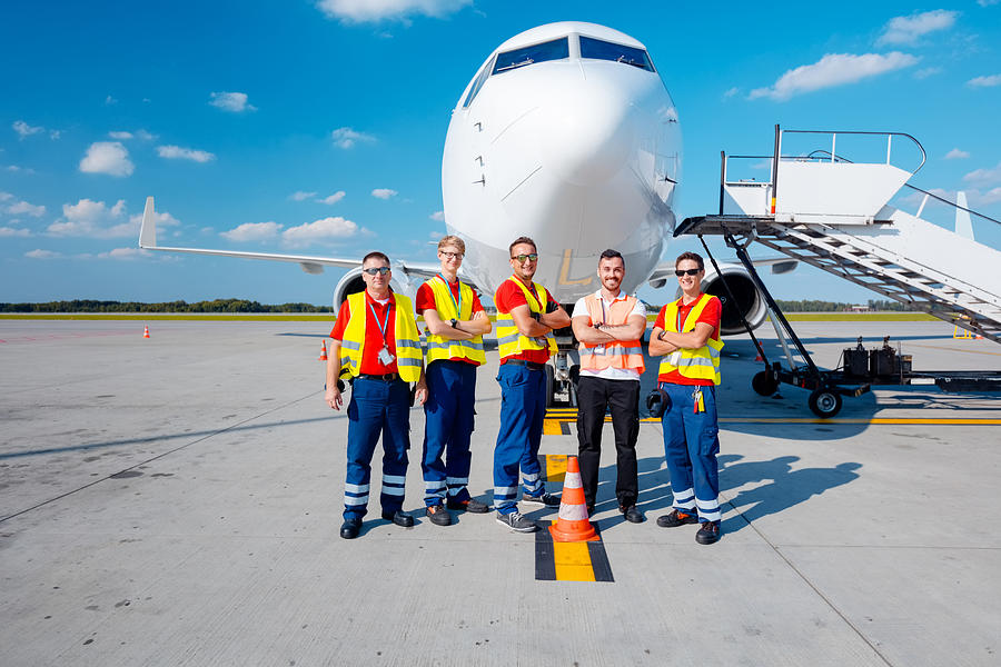 Airport ground crew in front of aircraft Photograph by Izusek