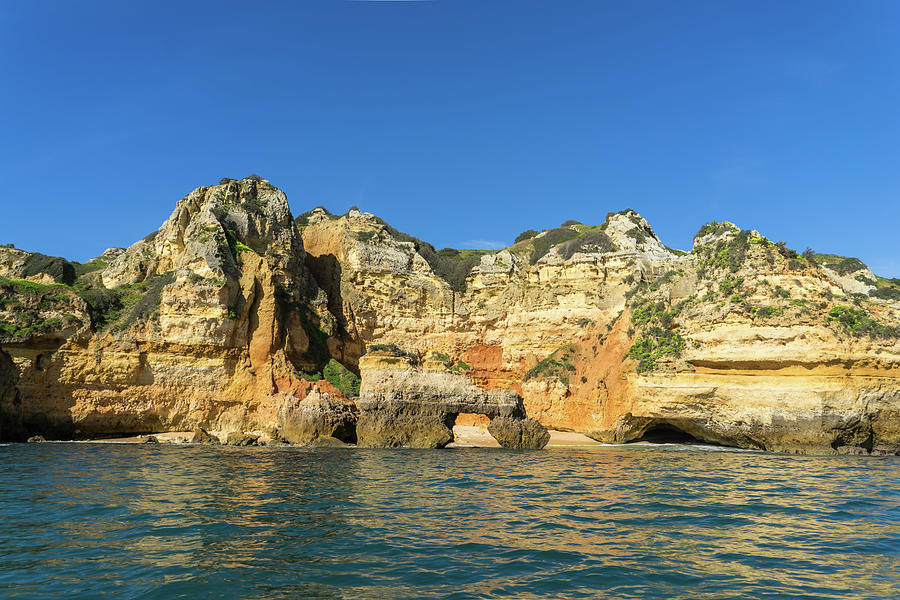 Algarve Gold Coast Sail - Boldly Colored Sea Cliffs with a Natural Arch in Lagos Portugal Photograph by Georgia Mizuleva