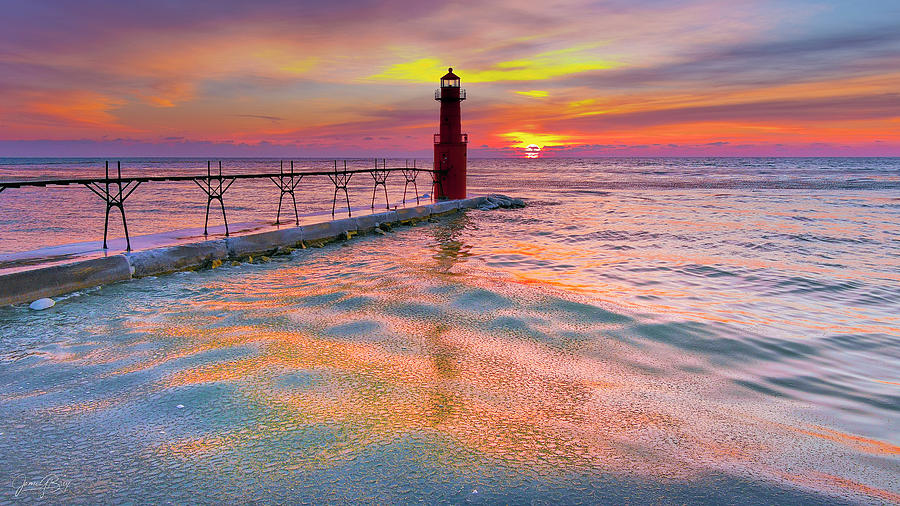 Algoma Harbor covered in pancake ice, reflecting the colorful sky at ...