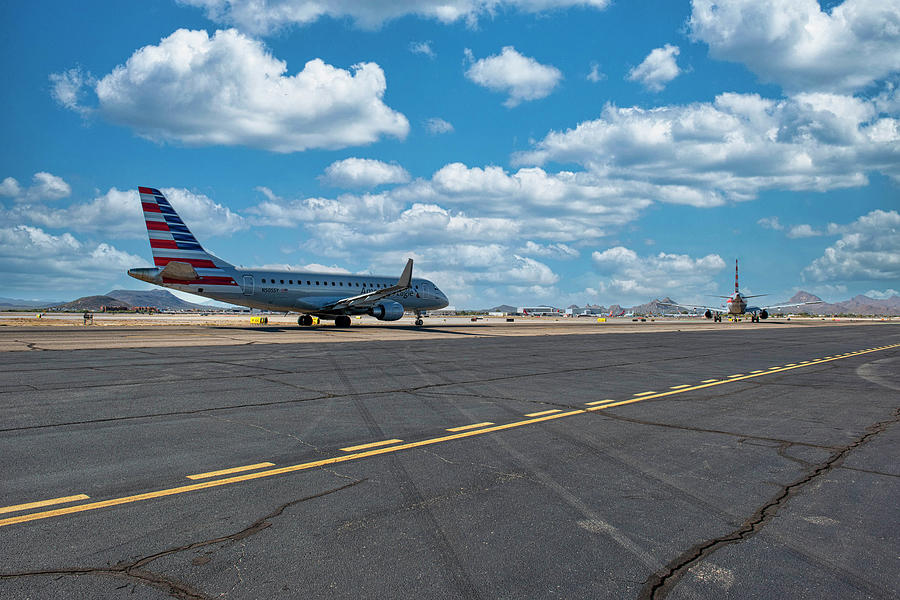 American Airlines Eagle CRJ taxies behind a Boeing 767 to the ac Photograph by Chris Smith