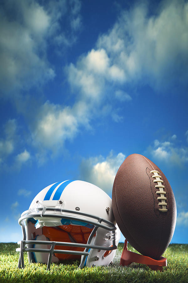 American Football and Helmet on Field Cloudscape Copy space Photograph by Skodonnell