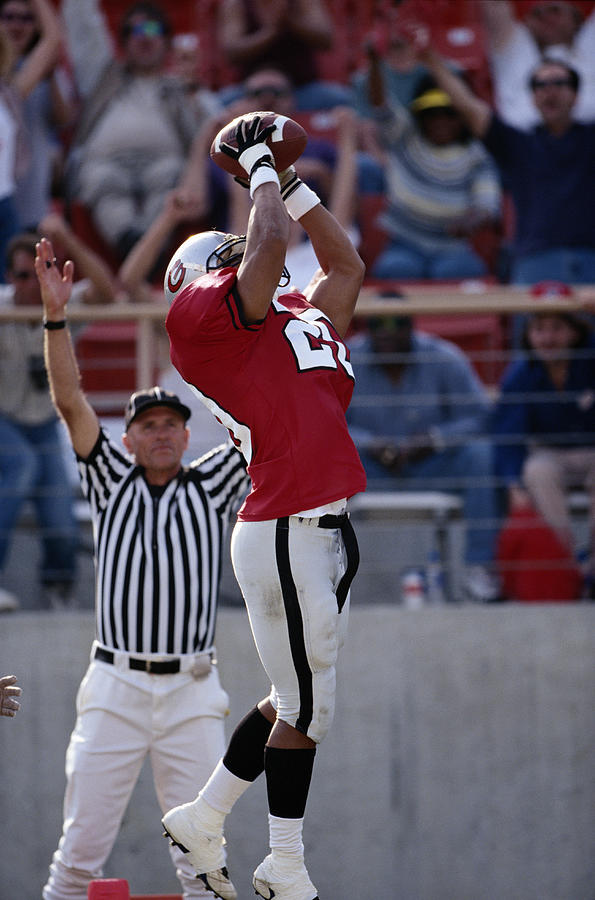 American football player catching pass for touchdown Photograph by Getty Images