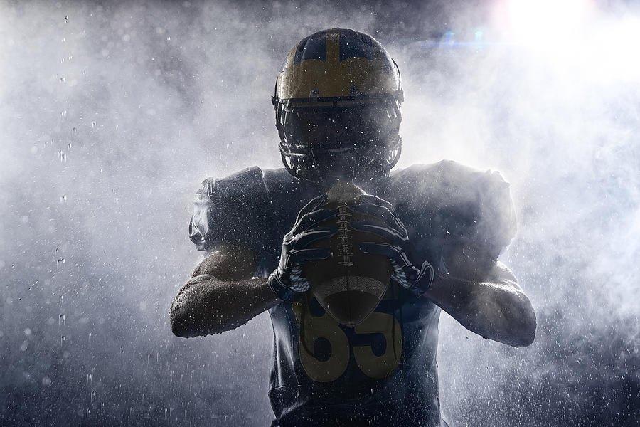 American football player in a haze and rain on black background. Portrait Photograph by Aksonov