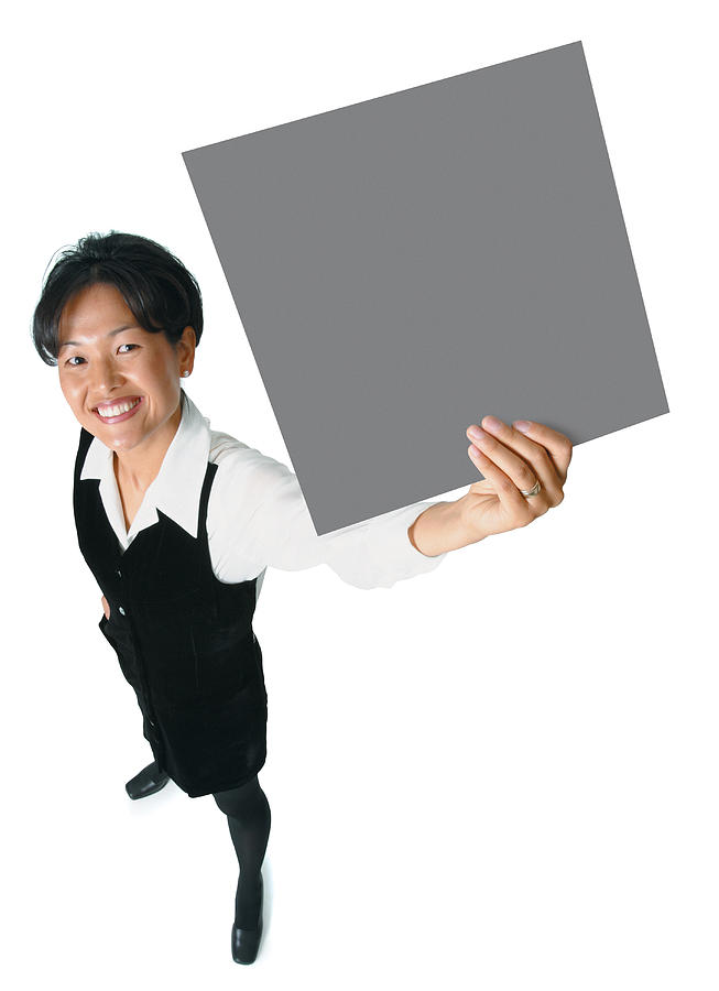 An Adult Asian Woman In A Black Business Outfit Holds A Sign Up To The Side As She Smiles Up Into The Camera Photograph by Photodisc