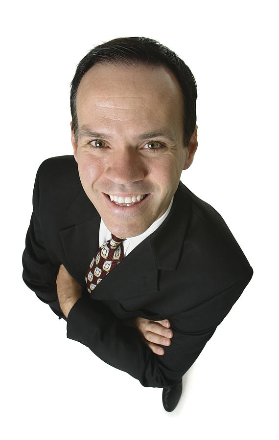 An Adult Caucasian Business Man In A Suit Folds His Arms And Smiles Up At The Camera Photograph by Photodisc