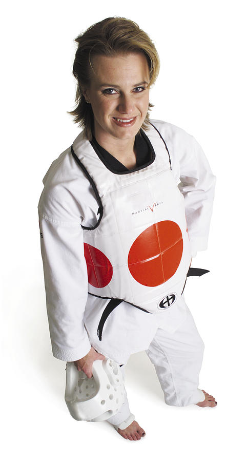 An Adult Caucasian Female Martial Arts Expert Wearing White Padding Holds Her Headgear And  Smiles As She Looks Up Into The Camera Photograph by Photodisc