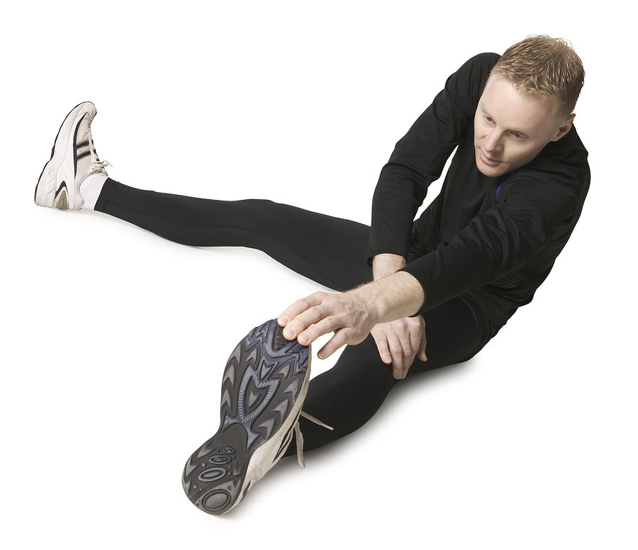 An Adult Caucasian Man In A Black Running Outfit Stretches Out And Prepares For A Jog Photograph by Photodisc
