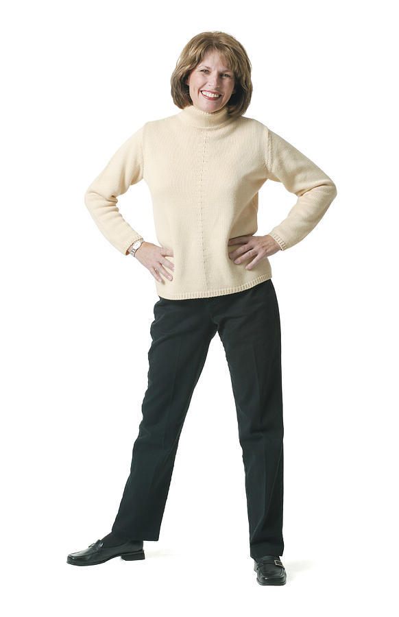An Adult Caucasian Woman In Black Pants And A Tan Sweater Puts Her Hands On Her Hips As She Smiles Photograph by Photodisc