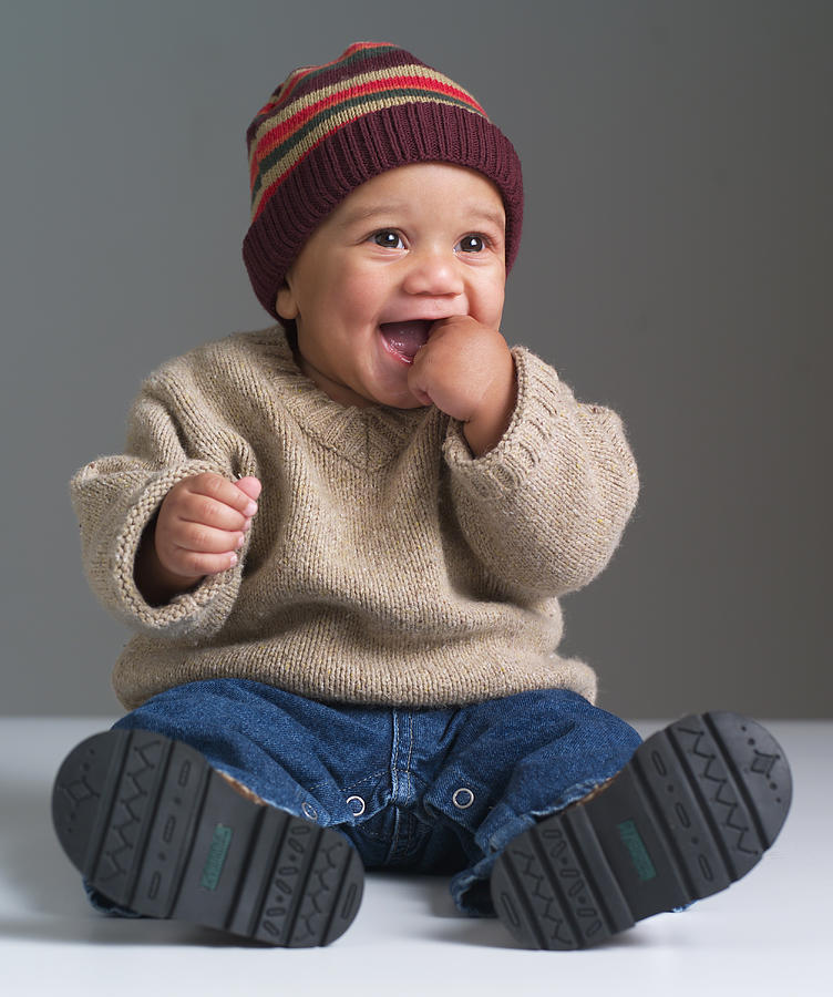 An African American Baby Puts His Hand In His Mouth And Laughs Photograph by Photodisc