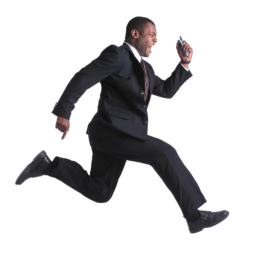 An African American Business Man Holds A Cell Phone And Leaps Through The Air Photograph by Photodisc