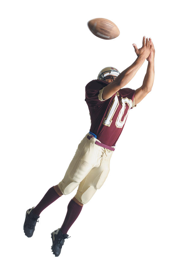 An African American Football Player In A Red And White Uniform Is Jumping Up With Arms Outstretched To Catch A Football Photograph by Photodisc