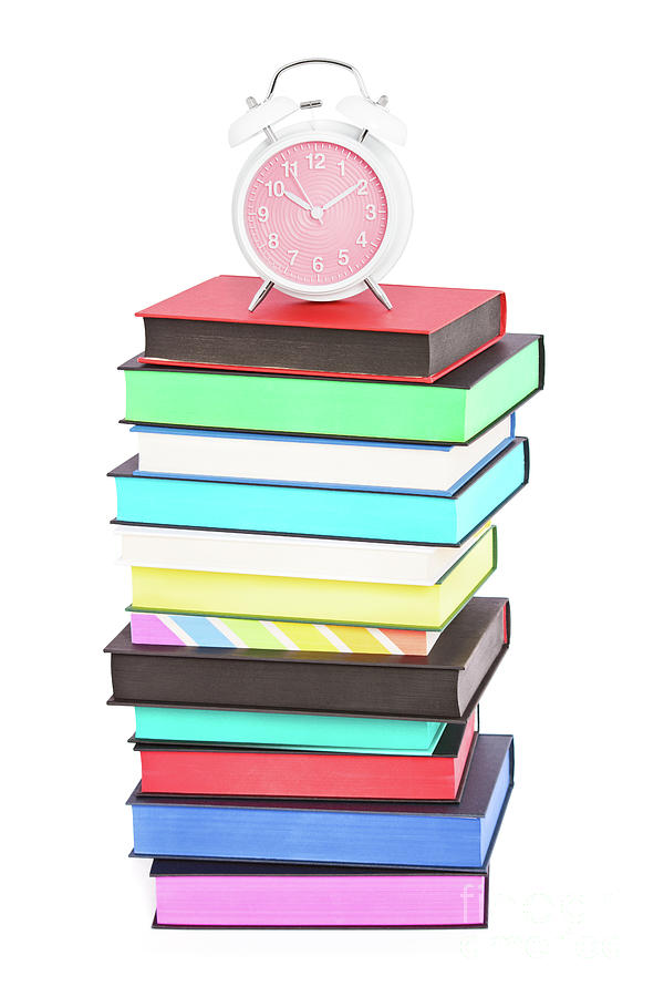 An alarm clock on top of stack of colorful books Photograph by Mendelex Photography